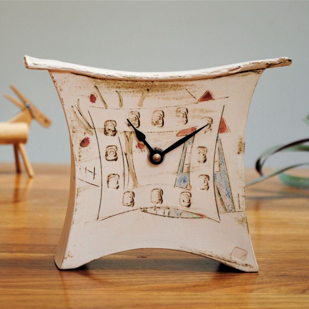 Handmade small ceramic mantel clock with a house and tree design. 