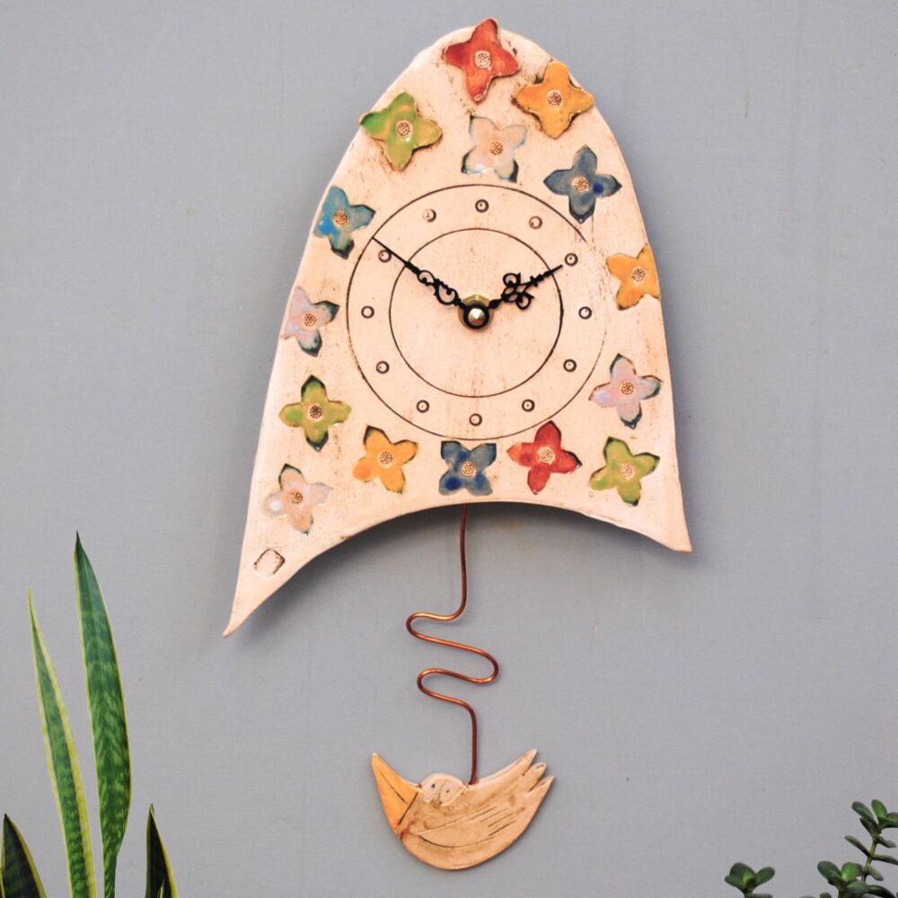 Small ceramic pendulum wall clock with flowers.