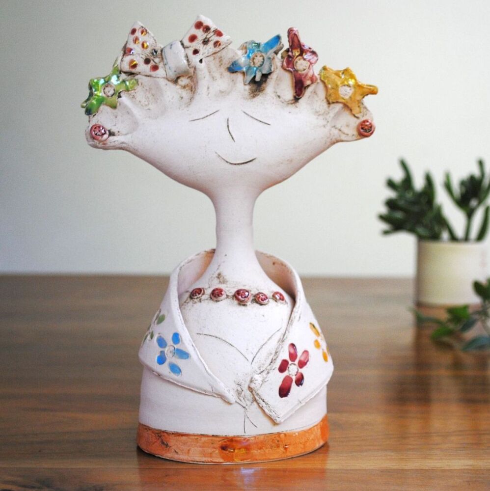 Ceramic lady statue with bow and colourful flower print.