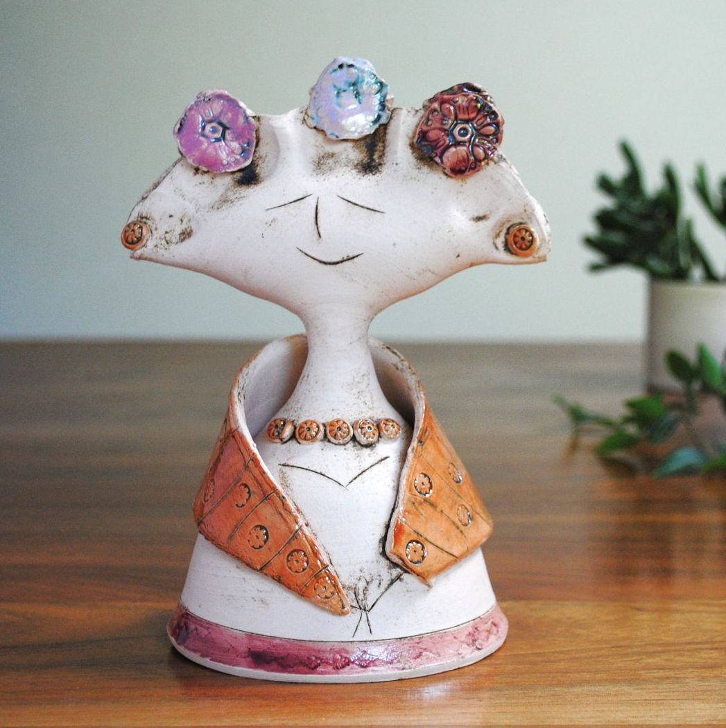 Pottery lady statu in pink, orange and red.