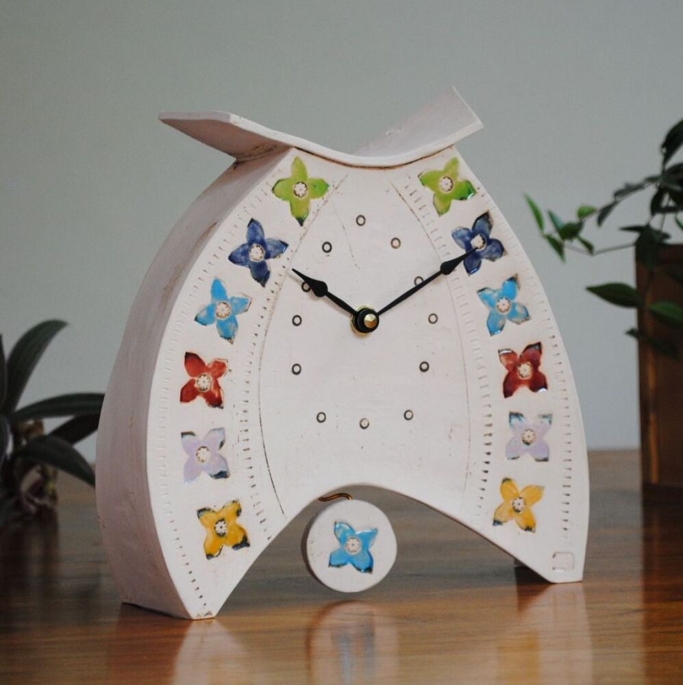 Handmade pottery clock off-white in rainbow colours.