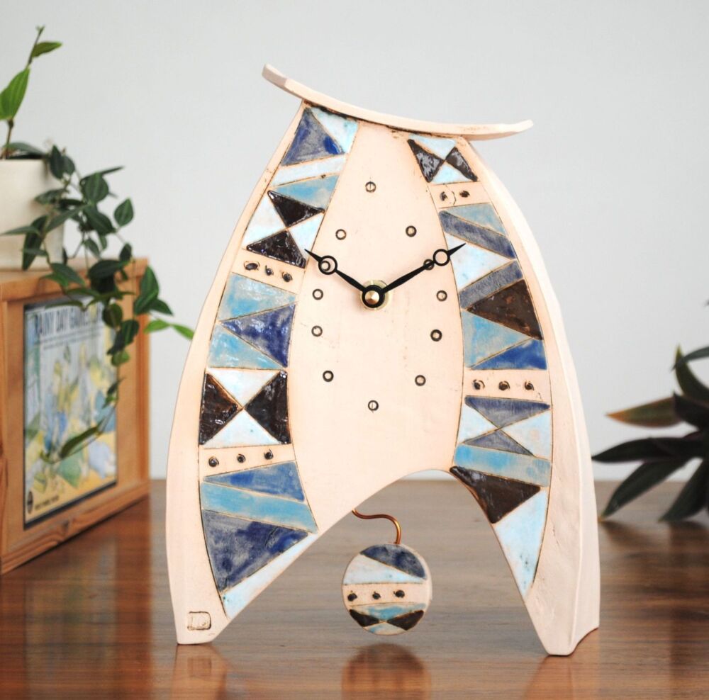 Handmade ceramic clock with a blue geometric design.