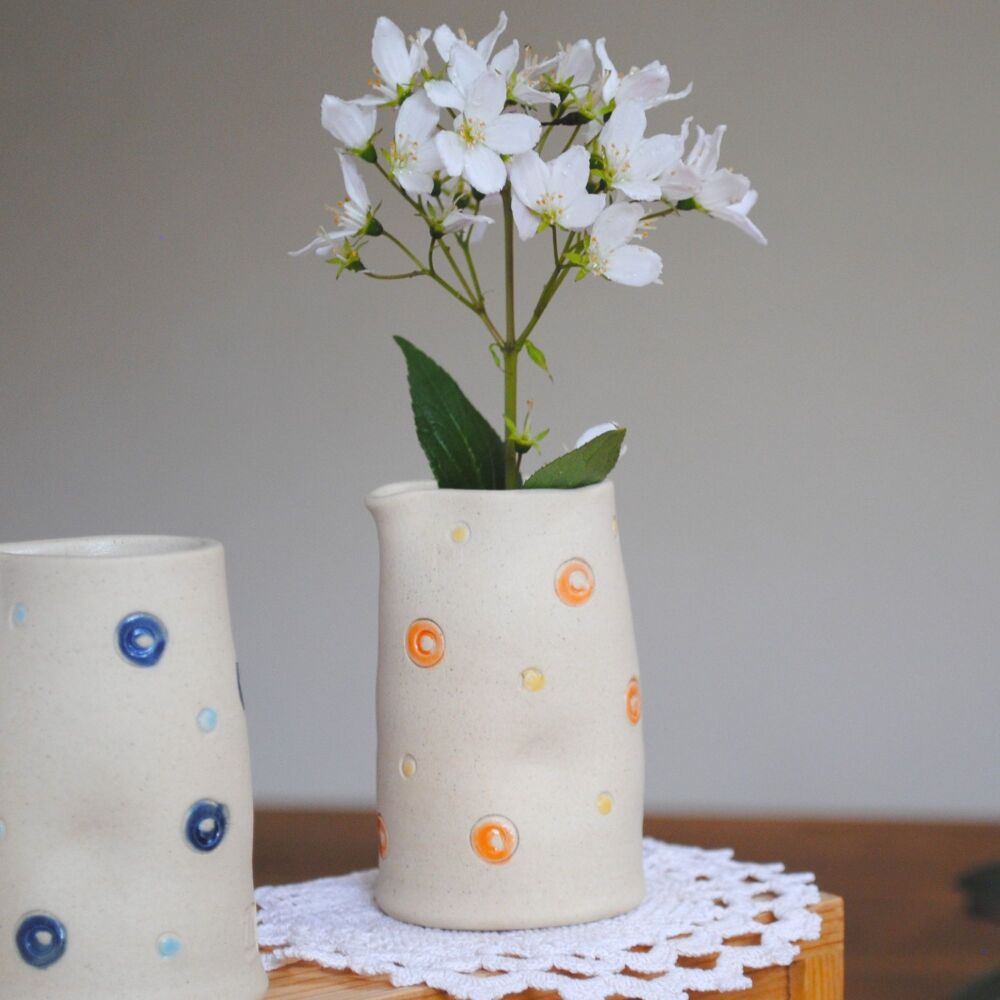 Vase jug with dimples and orange and yellow details.