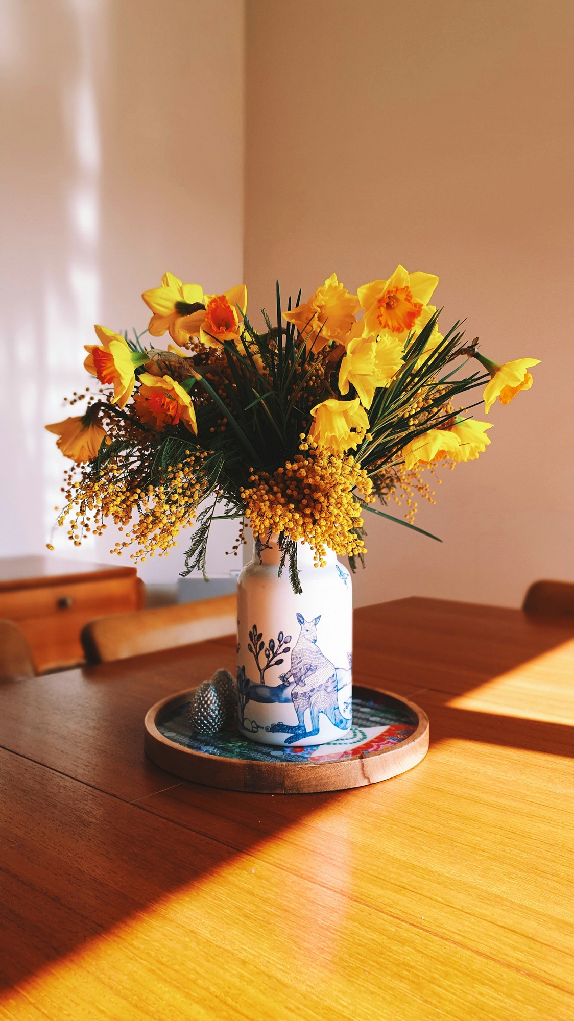 vase of daffodils on dining table