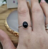 Black onyx and silver gemstone ring modelled on a hand