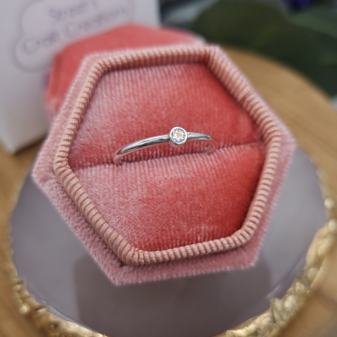 Aurora Ring, rainbow dazzling CZ stone set in a handmade sterling silver tube set ring, pictured in a soft blush pink box