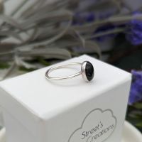 Side profile of a silver ring set with a black onyx gemstone