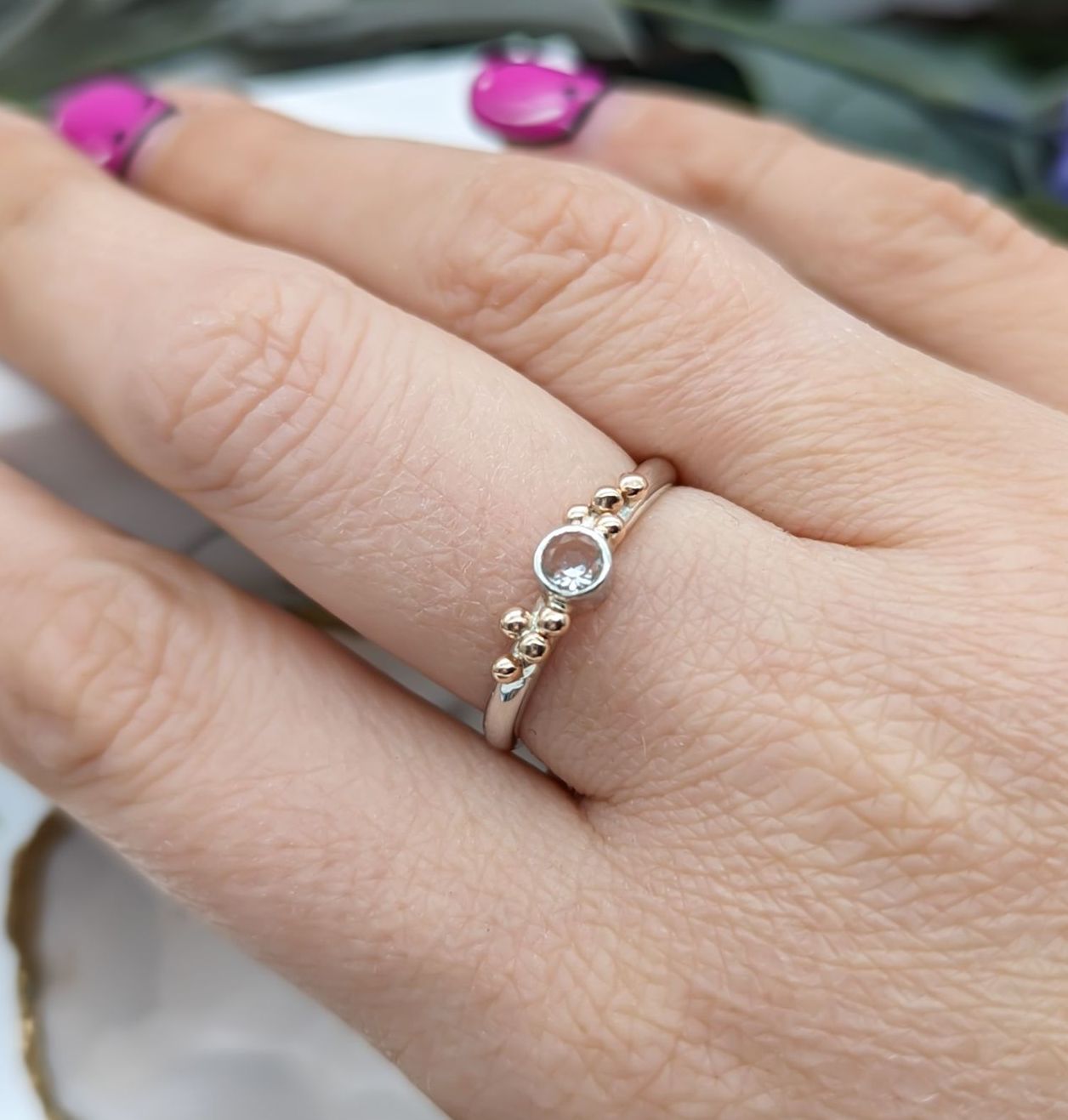 A modelled White Topaz & Rose Gold Granulation ring
