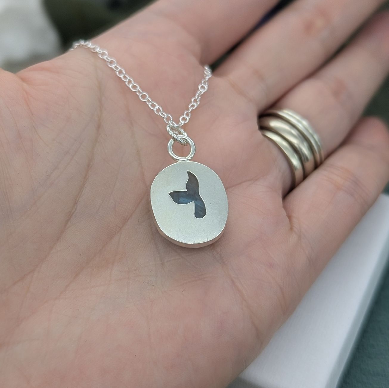 The reverse of the silver whale tail necklace showing the cut out detailing