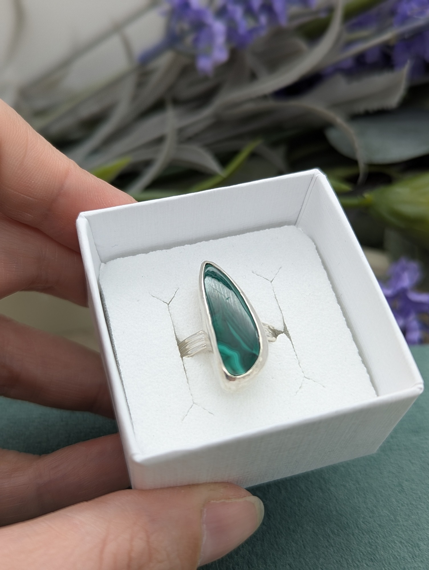 A free form Malachite silver ring inside a white ring box
