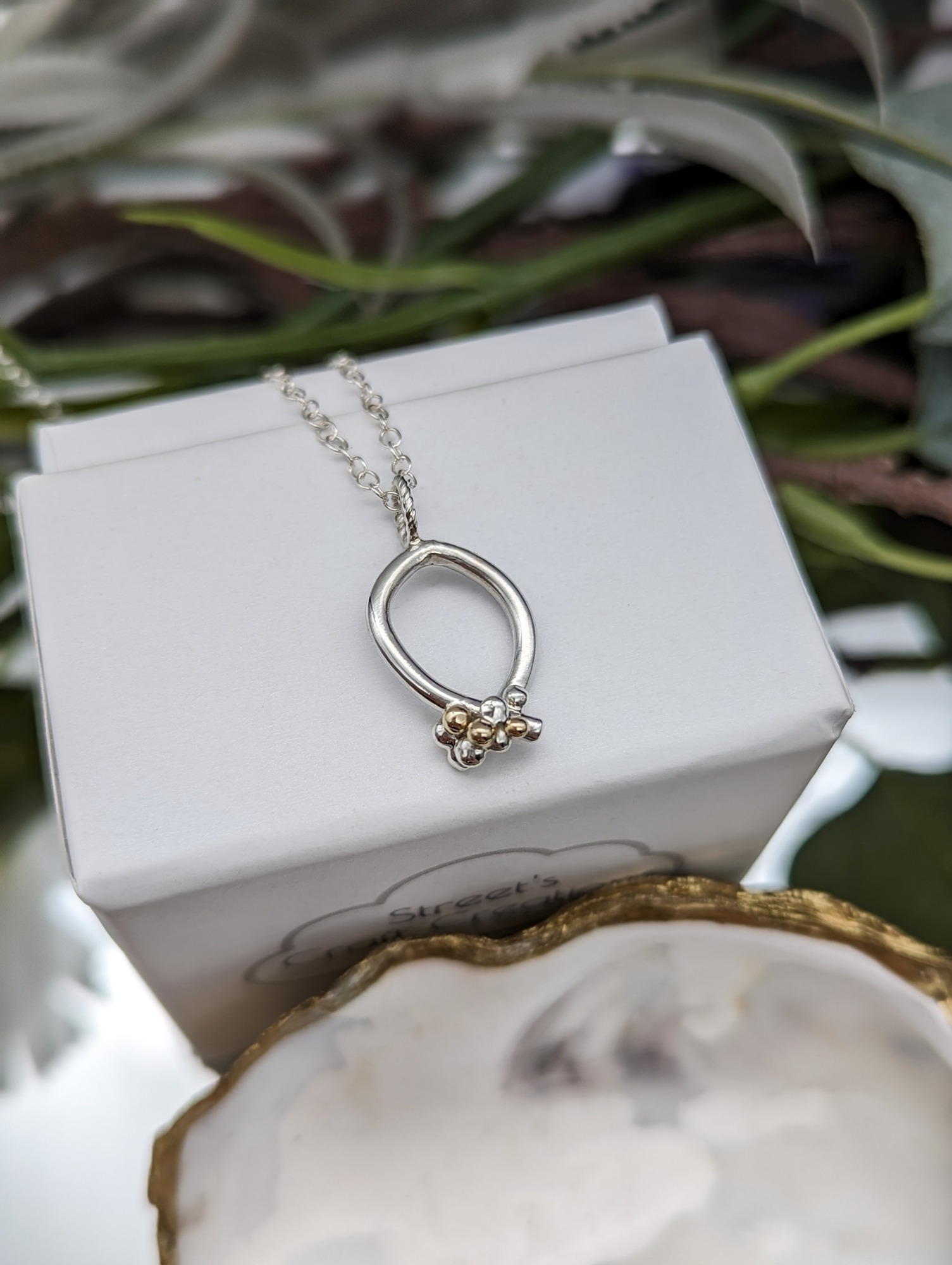 Silver & Gold granulation necklace on a white jewellery box 