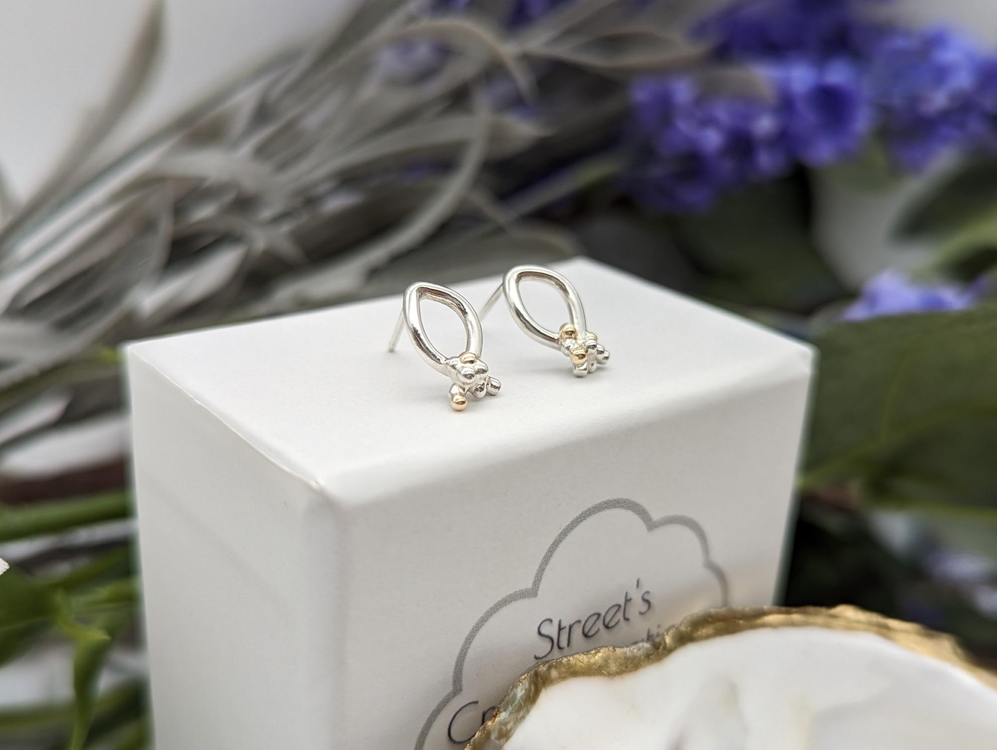 Silver & gold granulation earrings resting on a white jewellery box