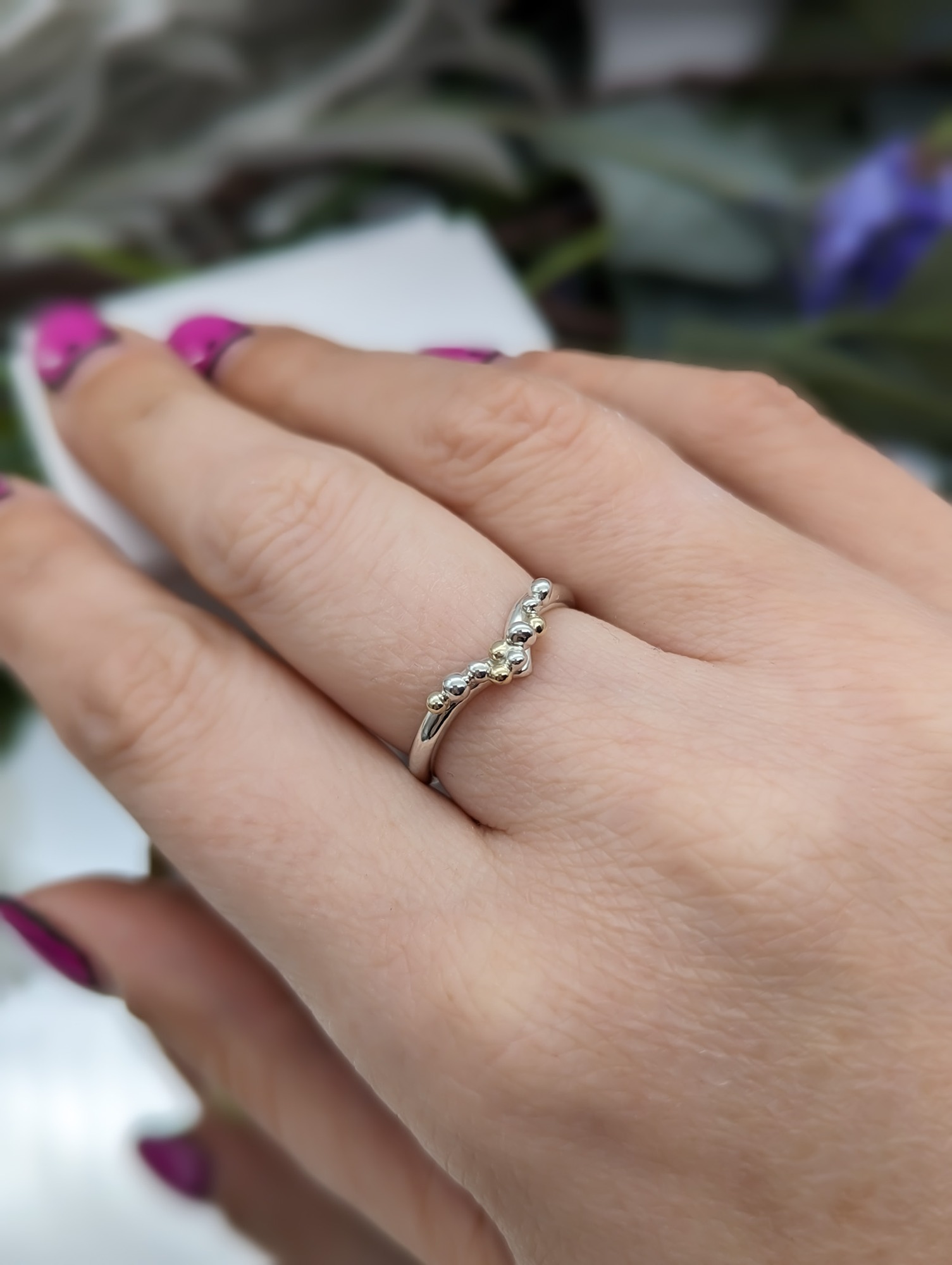 Silver & gold granulation wishbone ring on a hand
