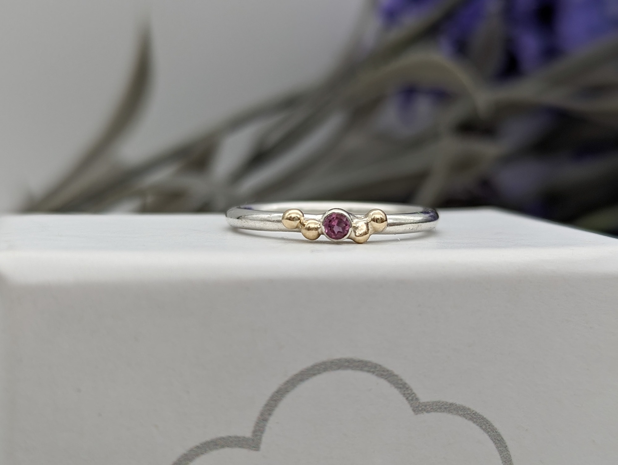 Pink tourmaline & gold granulation ring on a white jewellery box