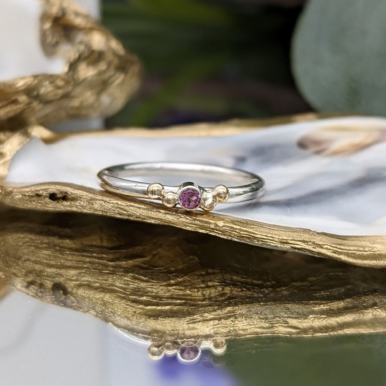 Pink tourmaline & gold granulation ring resting on a gold gilded oyster shell 