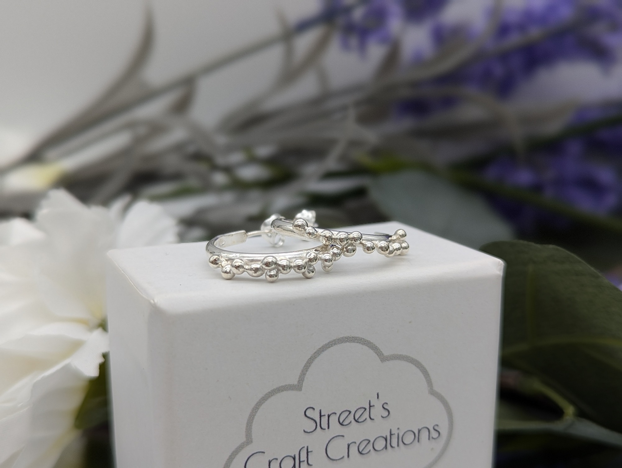 Half hoop silver granulation earrings on a white jewellery box