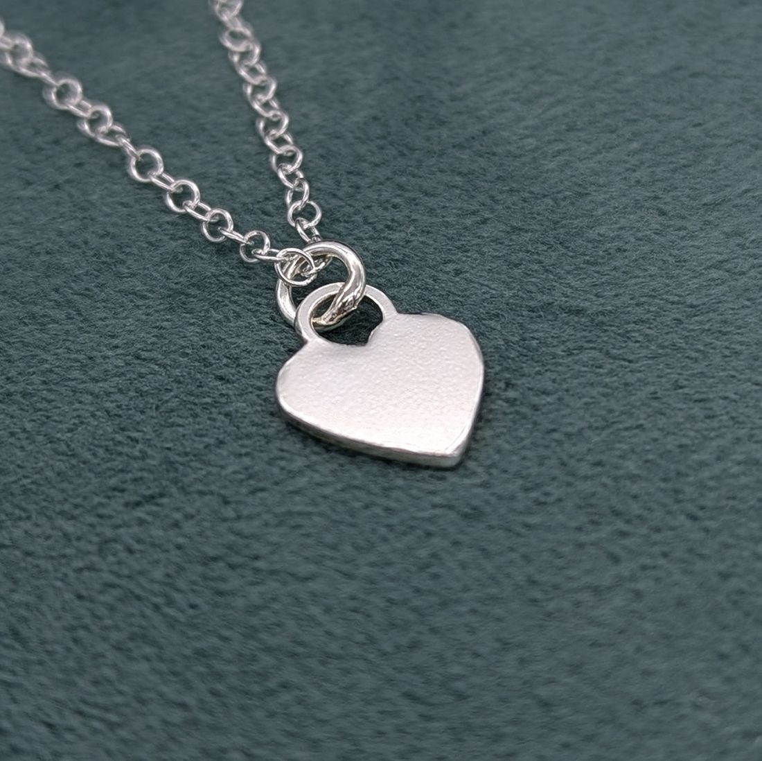 High shine finished heart necklace on a teal jewellery box