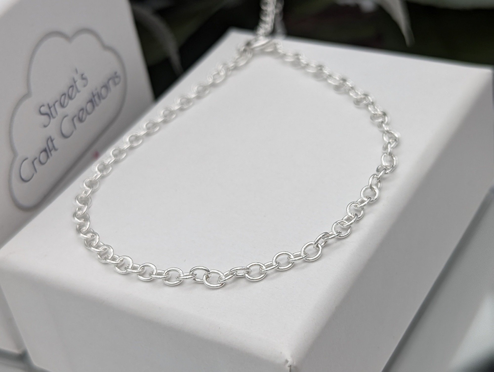 Silver trace chain bracelet on a white jewellery box