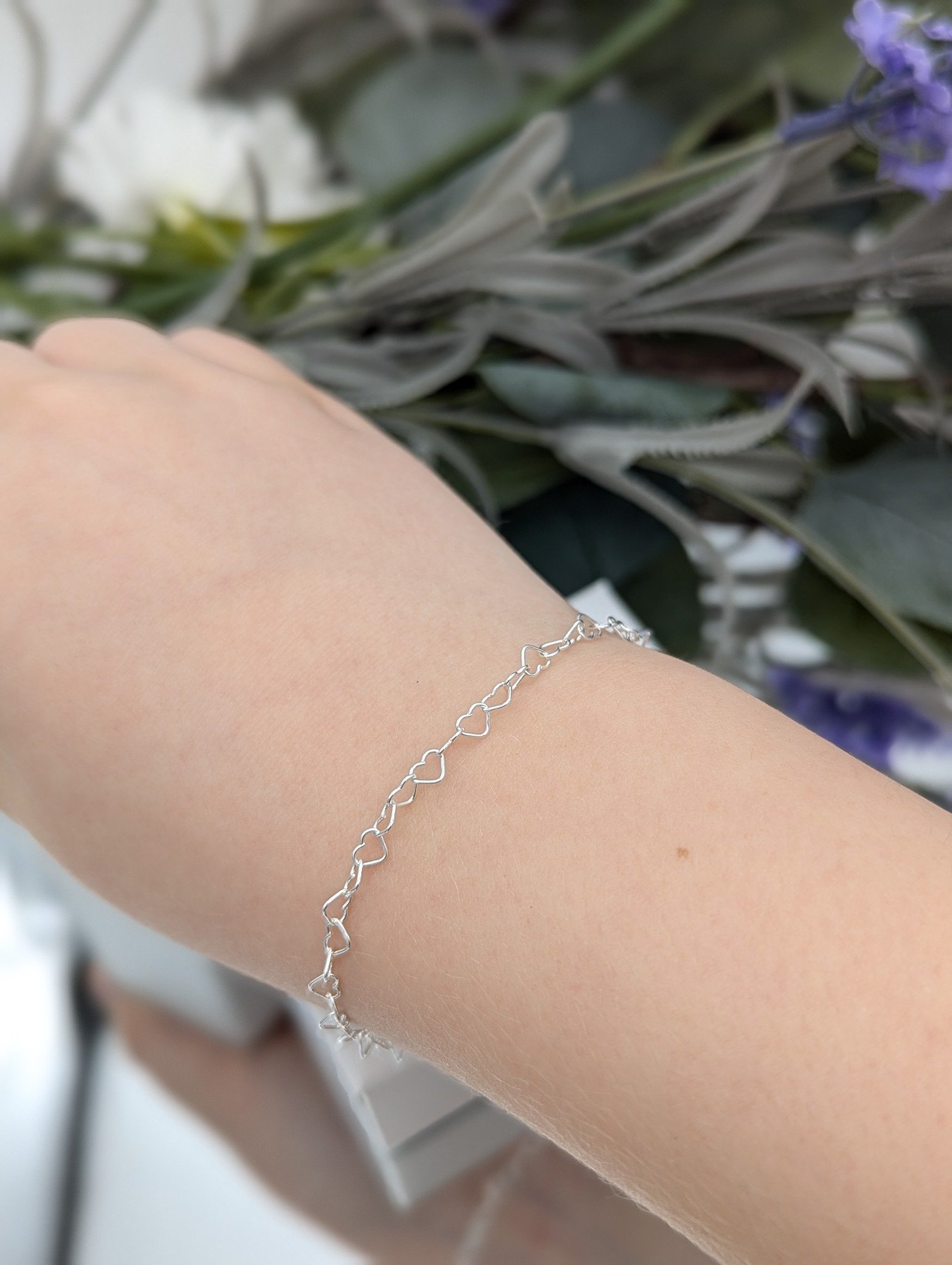 silver heart link bracelet modelled on a wrist