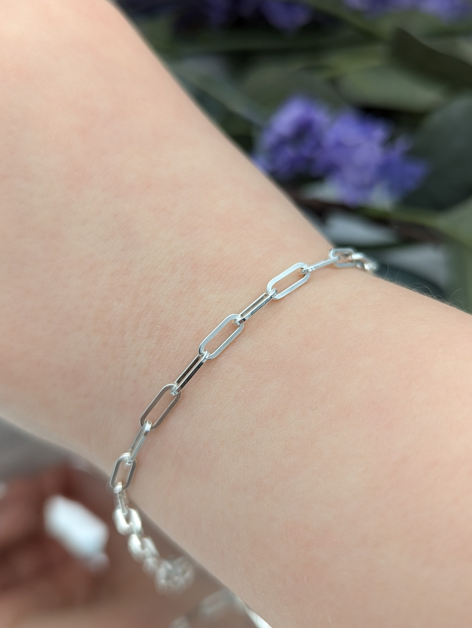 silver square link bracelet on a wrist
