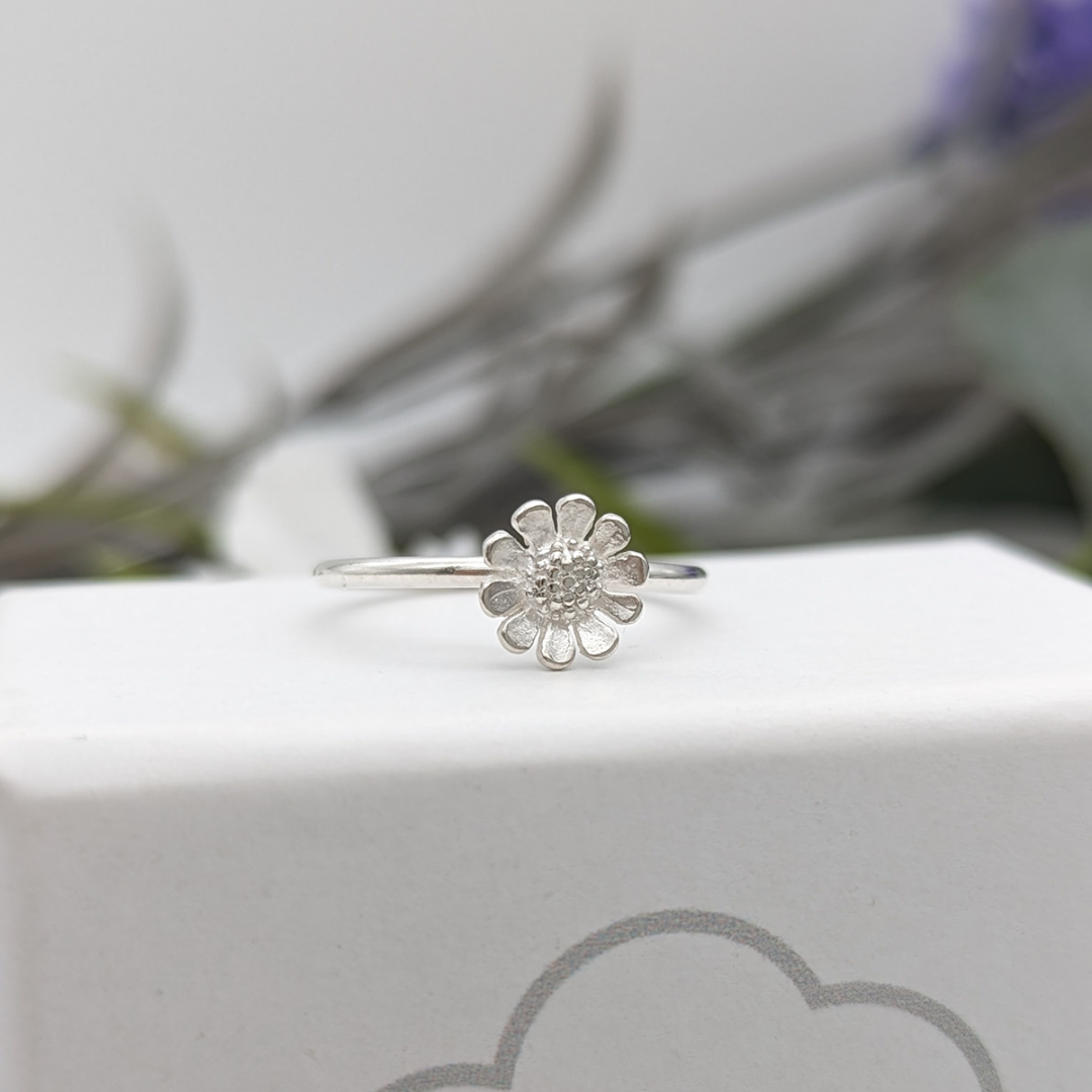 Silver daisy ring on a white jewellery box
