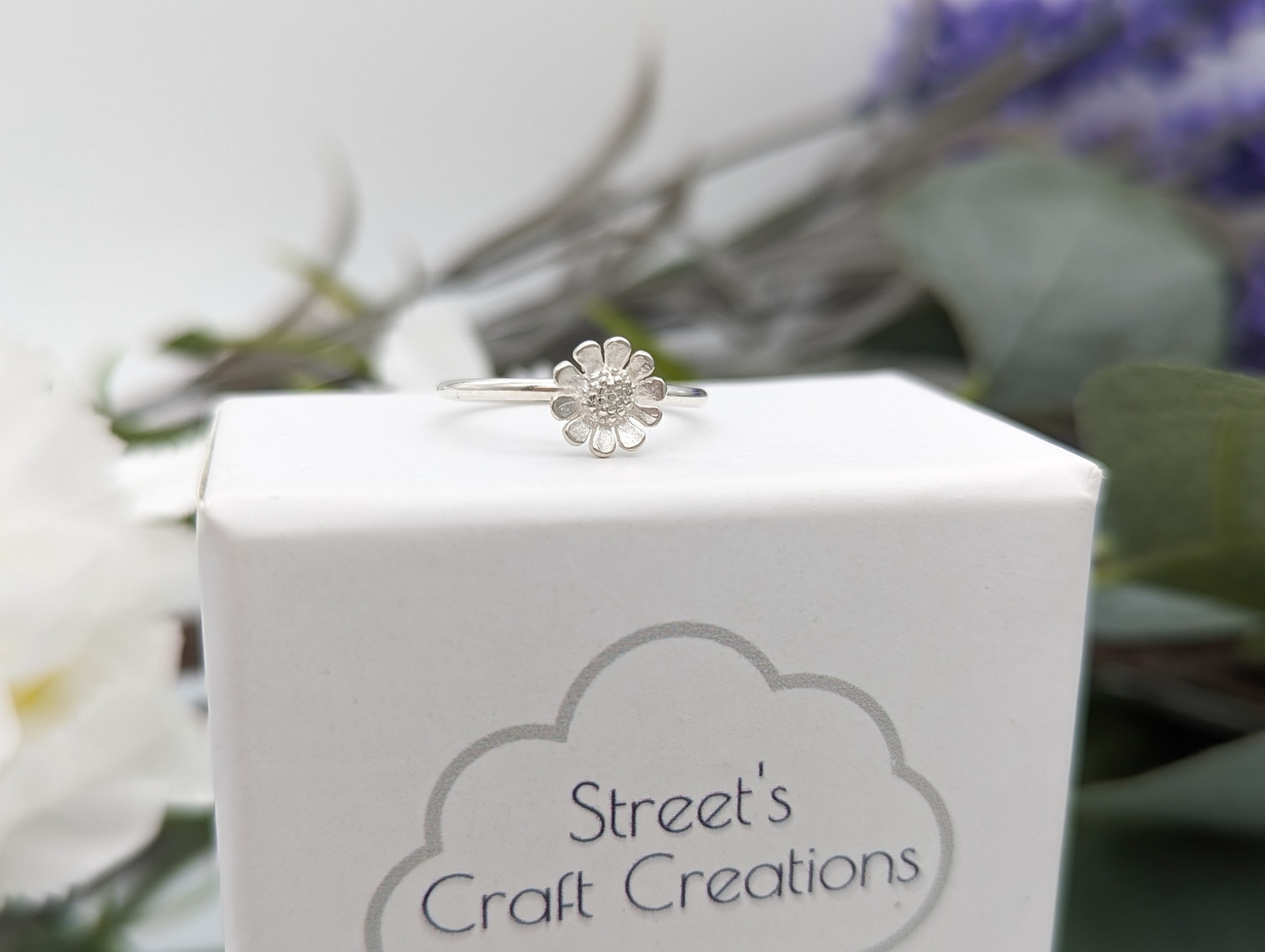 Daisy ring resting on a white box