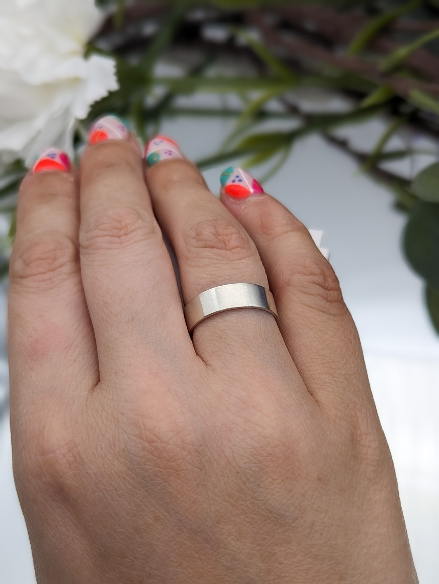 Silver brushed satin wide ring band modelled on a hand