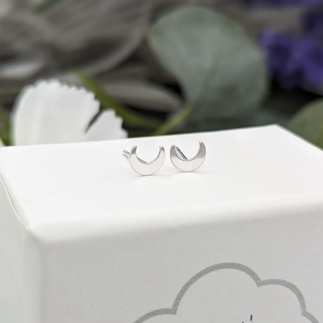 Crescent moon stud earrings on a jewellery box