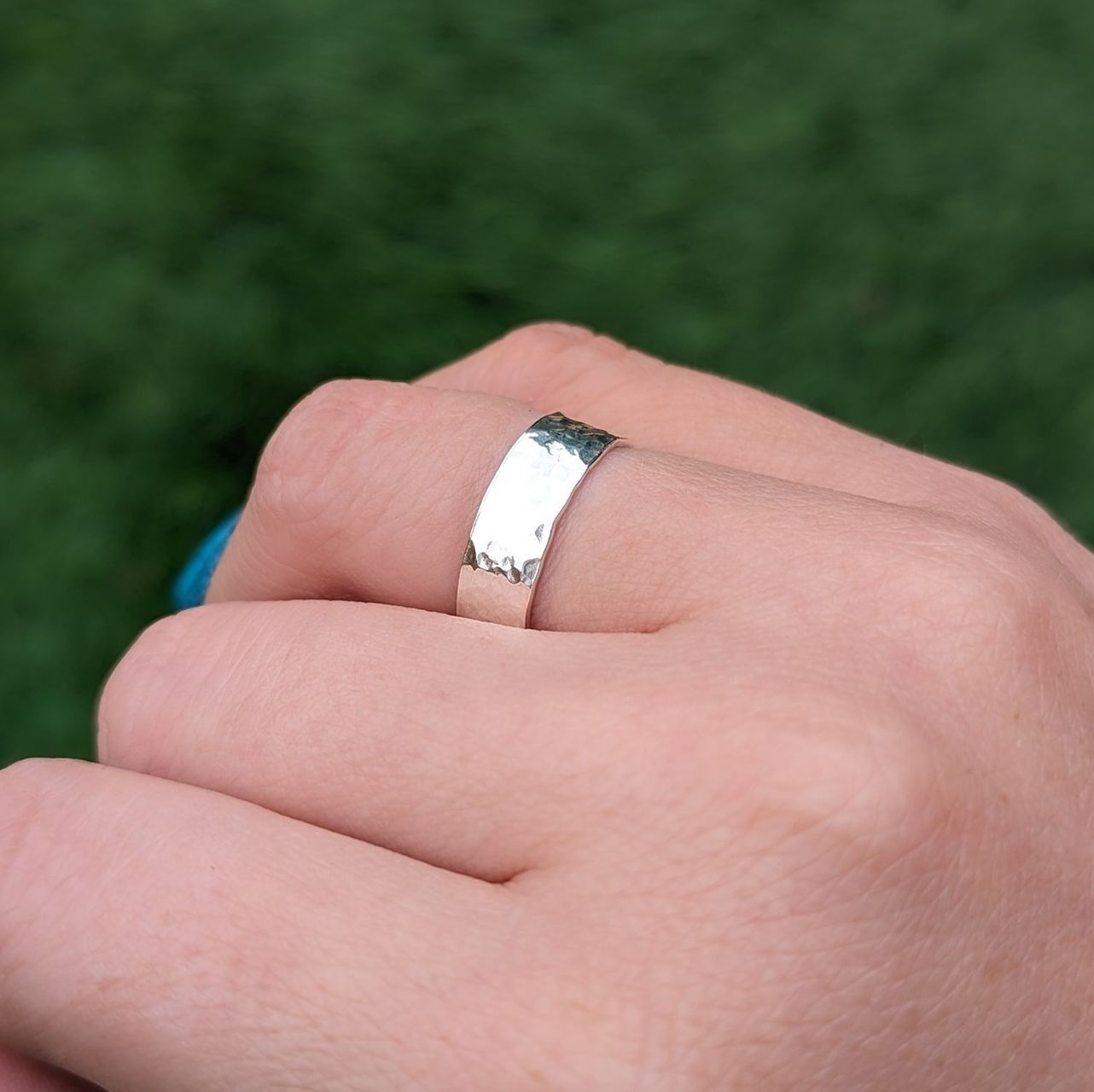 Textured wide band ring on a finger