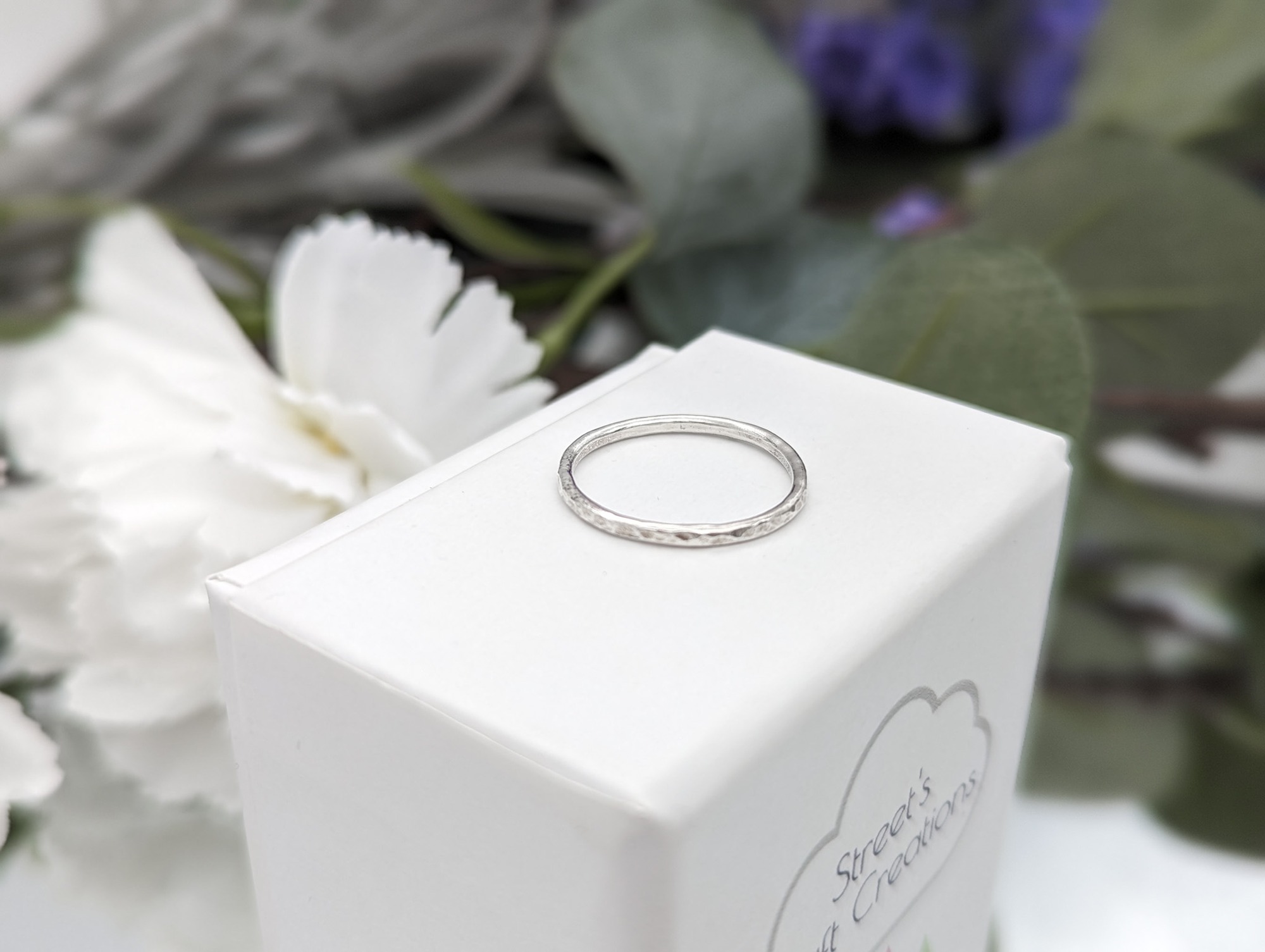 Stacking ring with a hammered finish on a white jewellery box