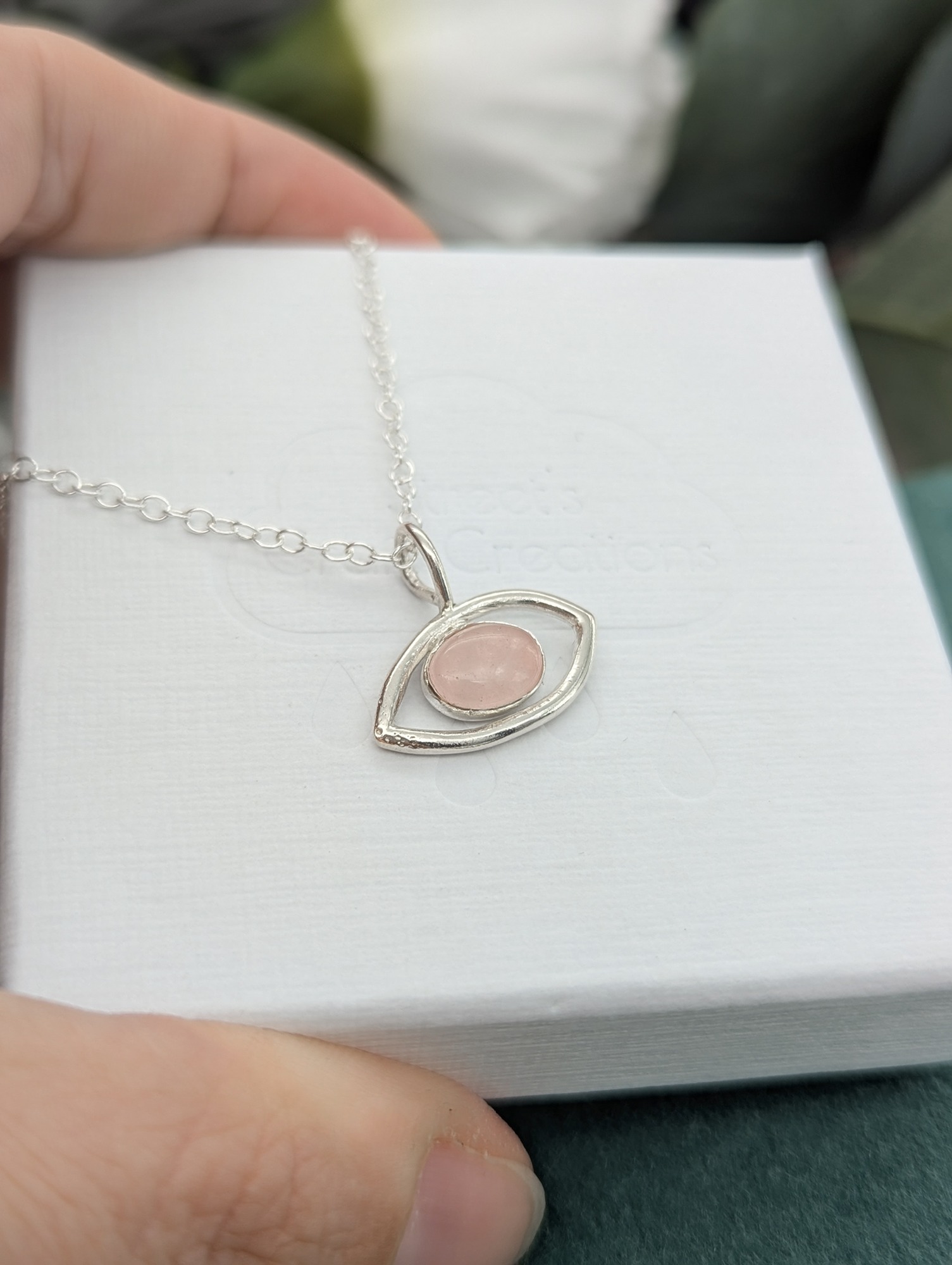 Rose quartz eye necklace on a white embossed jewellery box