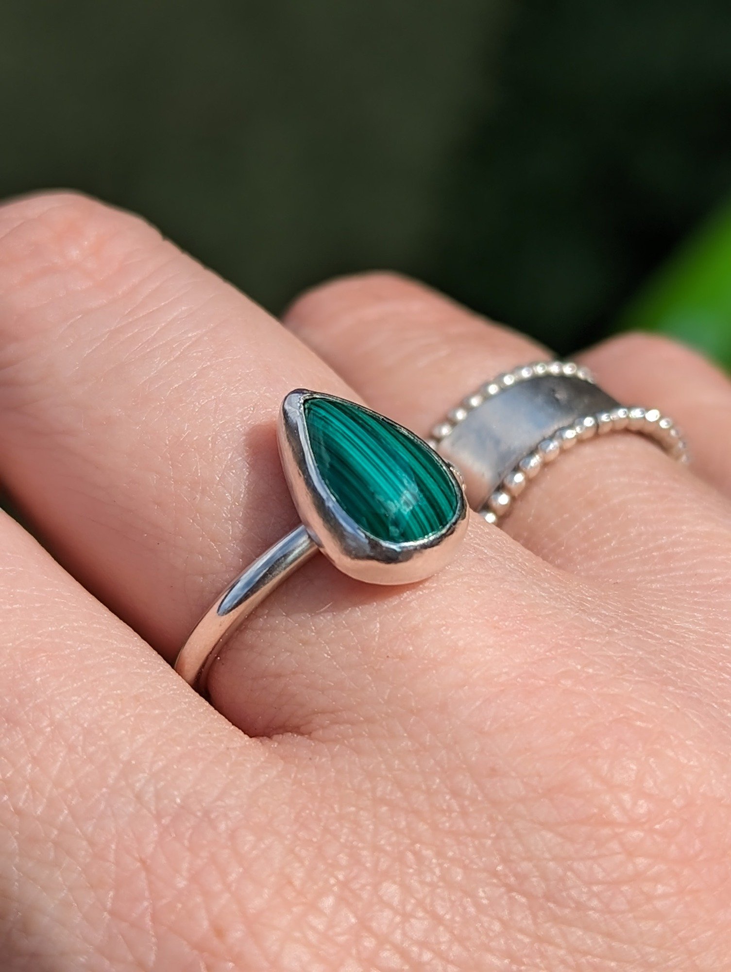 Malachite and silver ring being modelled on a hand