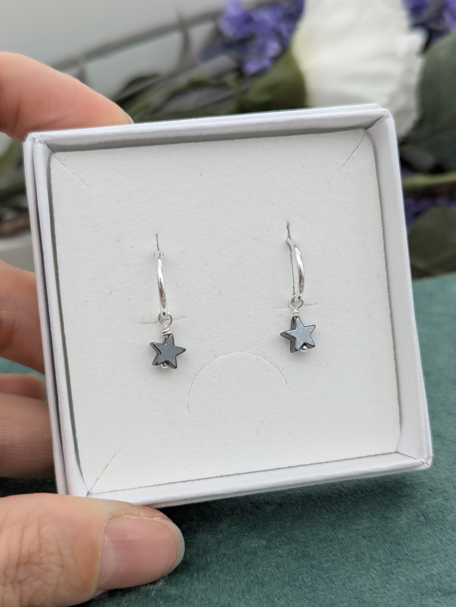 Silver hematite star hoop earrings presented in a gift box