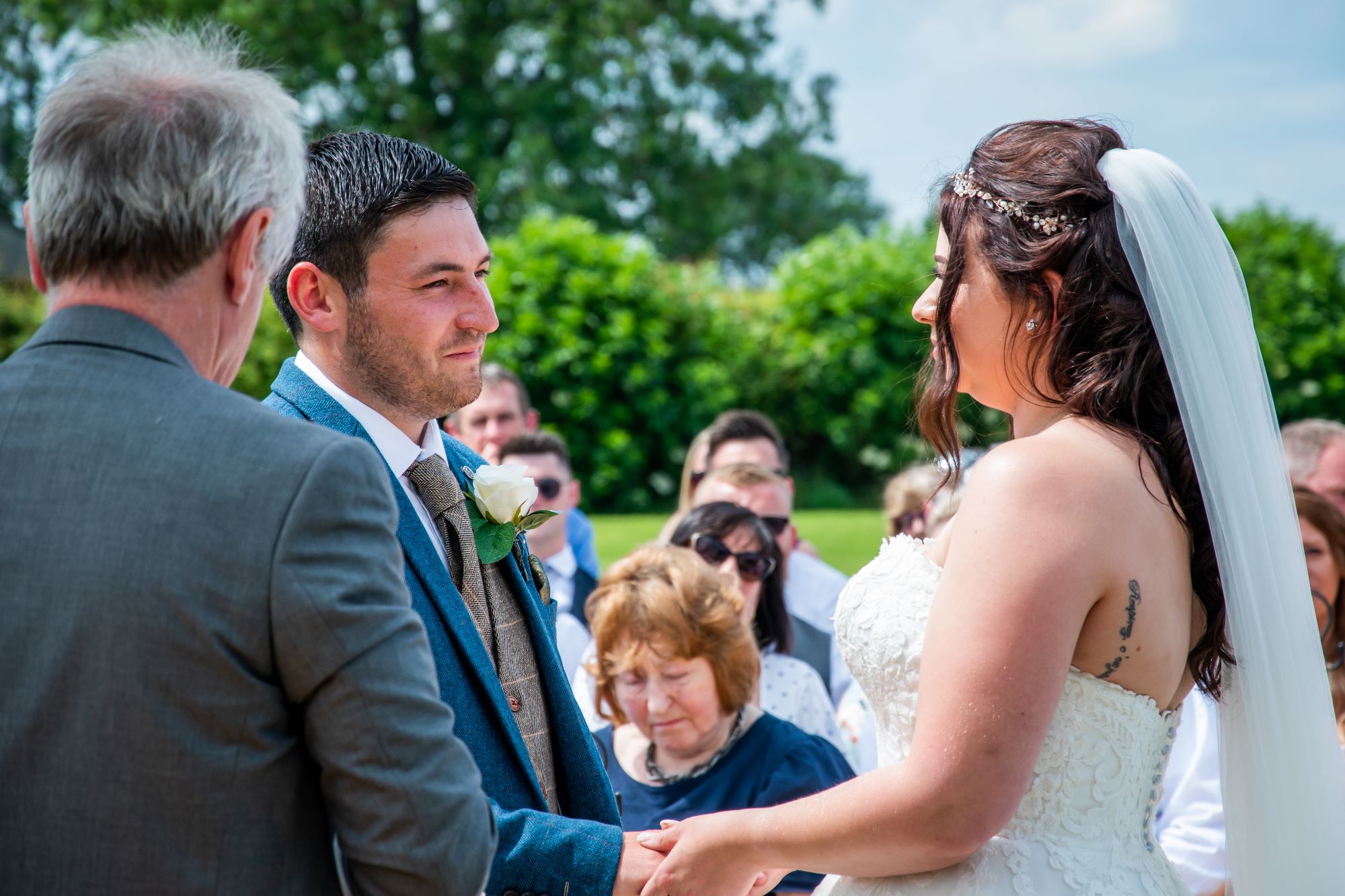 the bride and groom say their vows in front of their family and friends at an outdoor wedding in pickering, north yorkshire