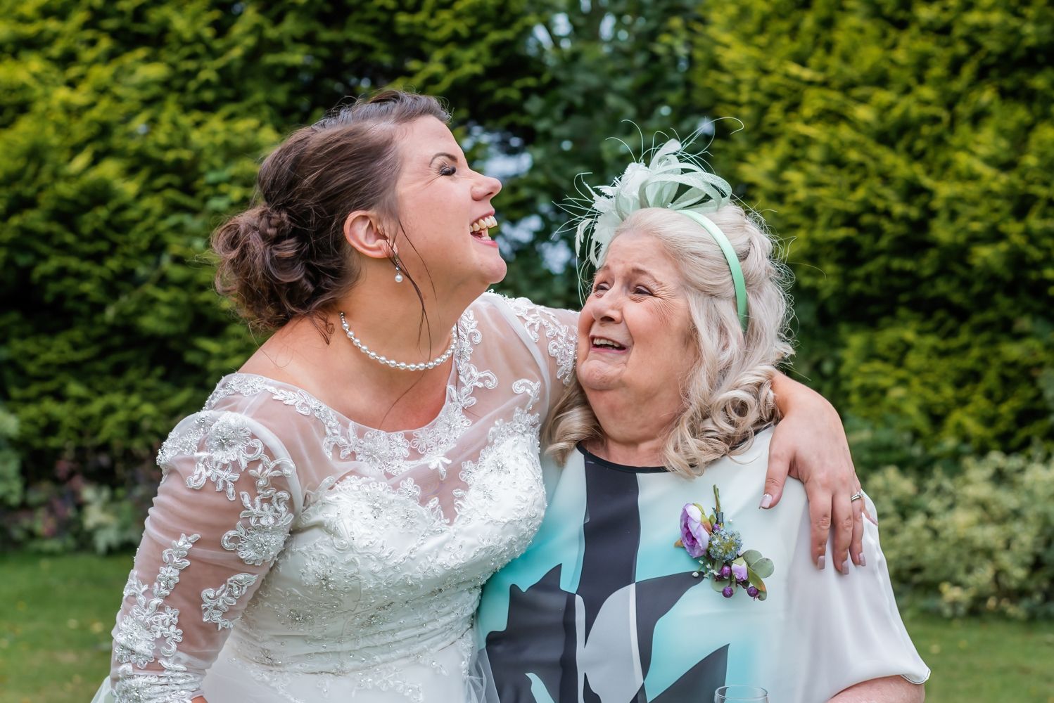The bride and her Mother laugh together during the family portraits