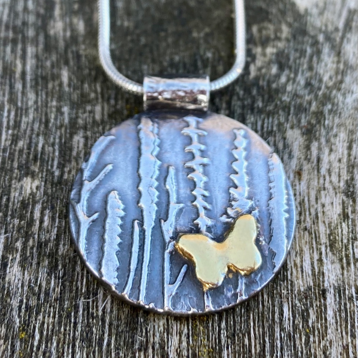 Circular pendant with wildflower meadow design