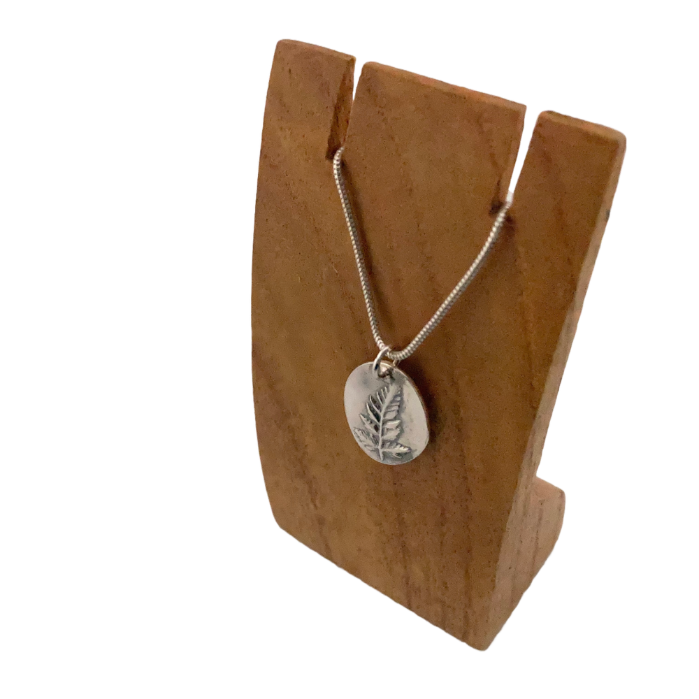 Oval pendant with an imprint of a real fern leaf, handmade in solid silver