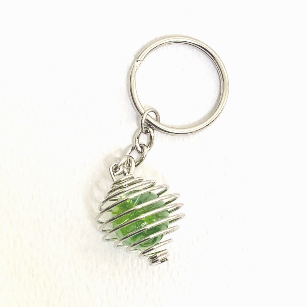 Green vintage glass marble in silver cage on a key chain