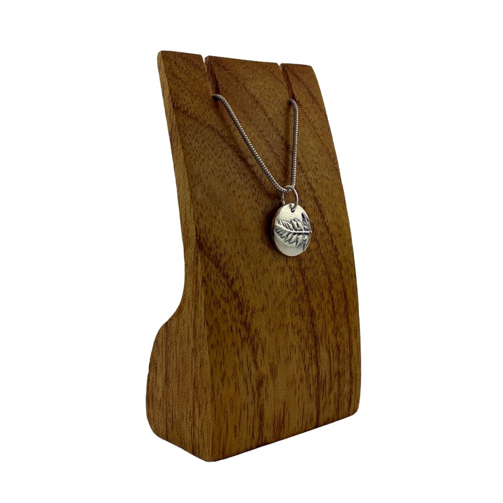 Circular pendant with an imprint of a real fern leaf, handmade in solid silver