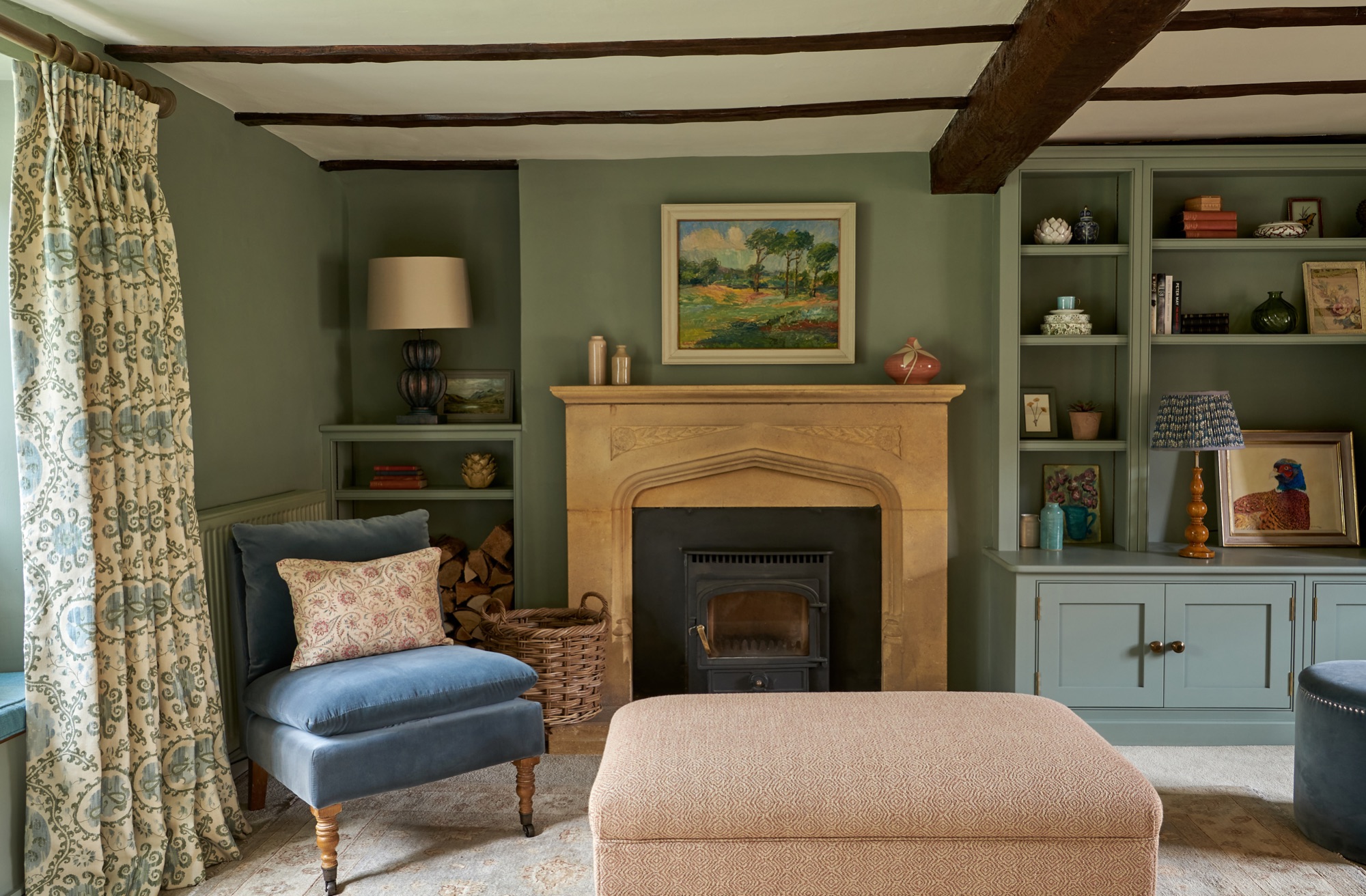 country house living room painted in farrow and ball , tv cabinetry units with brass hardware, hardware,pheasant artwork by Petra, and Pooky standing lamp 