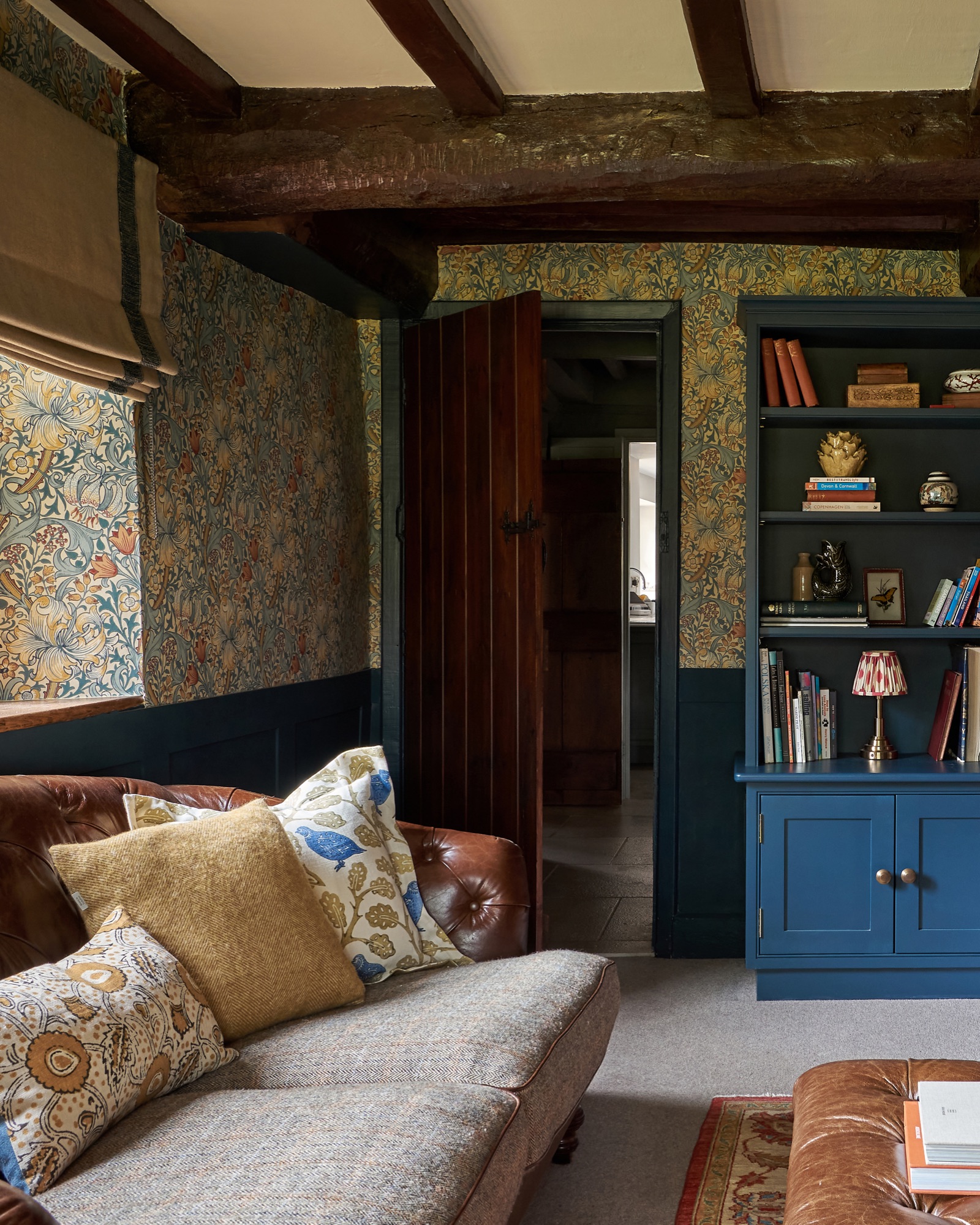 snug room in a country house, Hague blue farrow and ball  paint with William Morris wallpaper, tetrad leather sofa with  tweed mill  and Linwood cushions