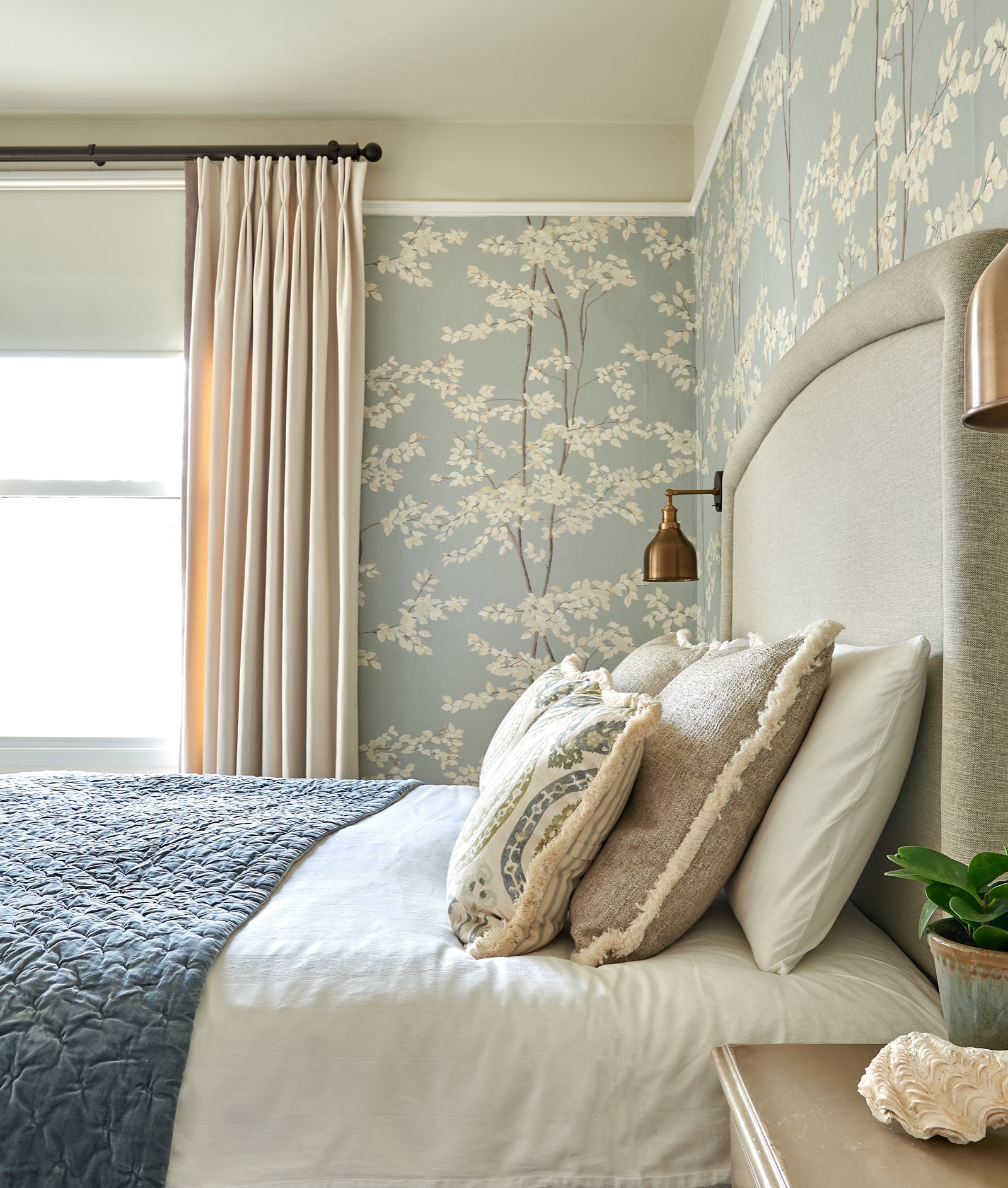 Beautiful calming master bedroom wallpapered in Lewis and wood Beech wallpaper and industville wall lights. Lewis and wood Benaki and Andrew Martin cushions and a velvet blue Oka throw. Full length Romo curtains. Elizabeth violet Home Cushions .