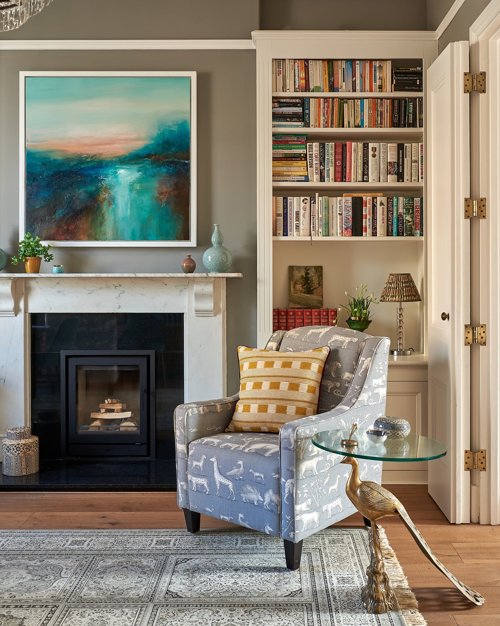 Beautiful Georgian town house painted in worsted farrow and ball, with styled book shelves and Andrew Martin upholstered armchairs and cushions.