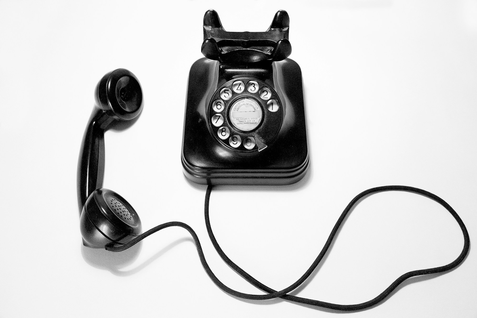black-rotary-dial-phone-on-white-surface-8gWEAAXJjtI