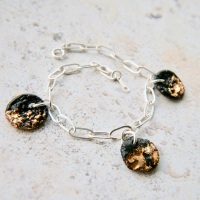 Sterling silver cable chain bracelet with black-gold charms, perfect for a party!