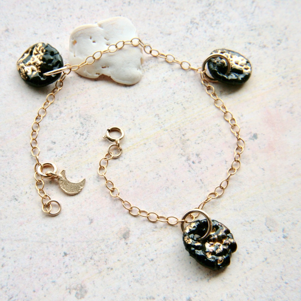 Charm bracelet with black-gold charms.