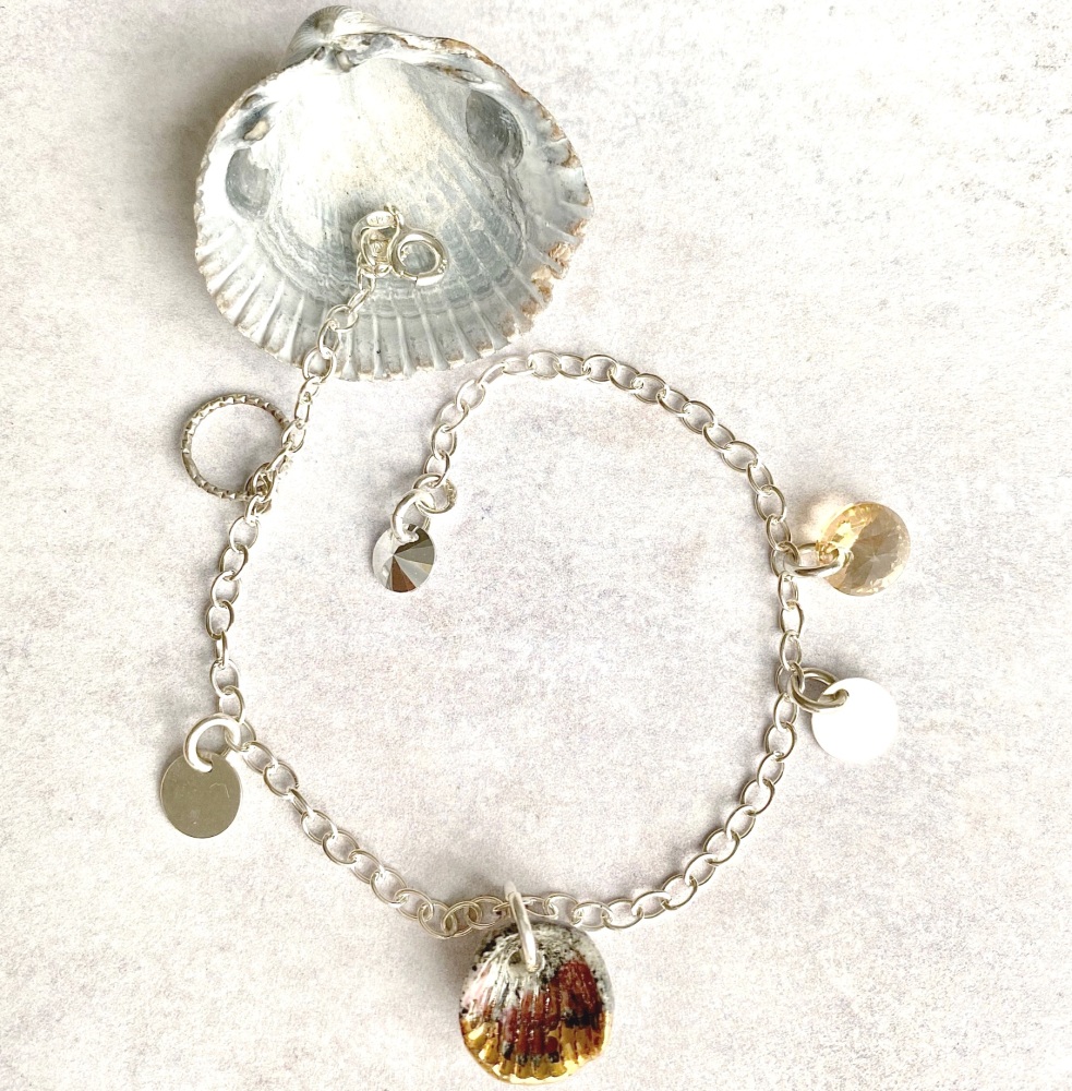 Sterling silver bracelet with porcelain seashell charm.