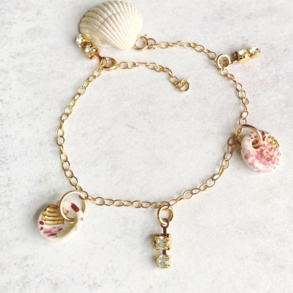 14k gold charm bracelet with handmade porcelain seashell and light pink cry