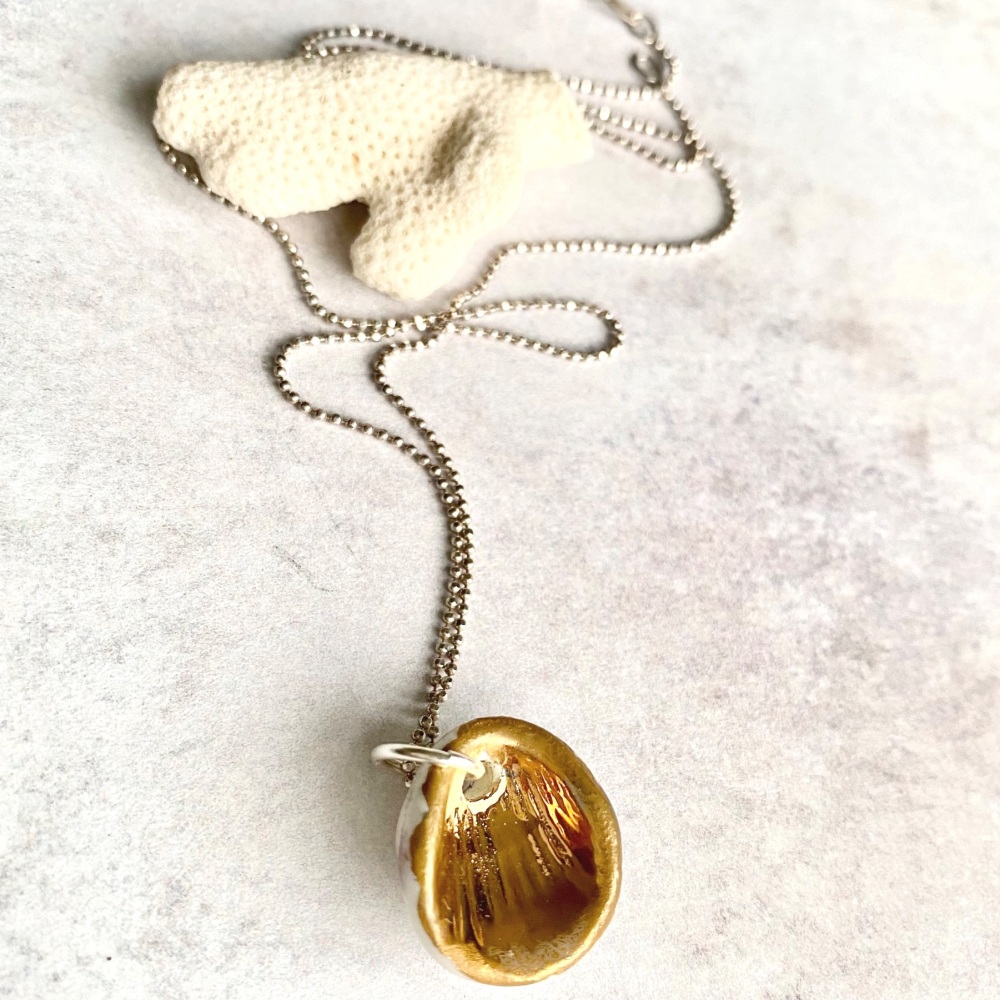 Silver necklace, gold shell