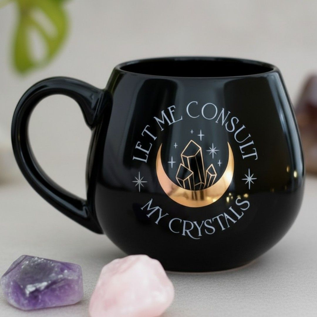 Black mug with gold moon and crystal design, crystals in foreground